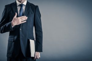 胸に手を当てる男性